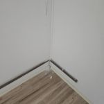 Lokálne poškodenie povrchovej úpravy steny s odlupovaním náteru a omietky.
